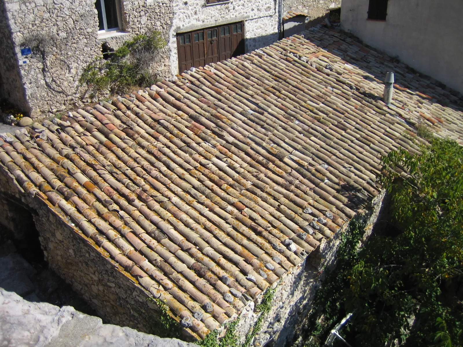 Toiture en tuiles canal anciennes sur une maison en pierre de Provence